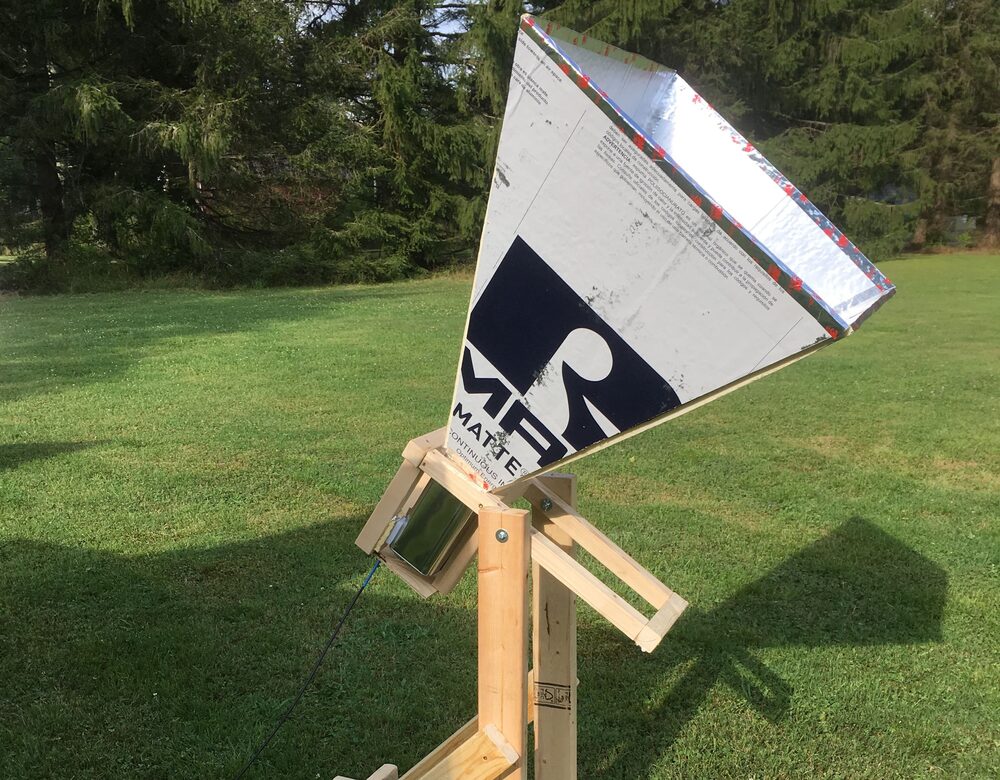 A pyramidal horn antenna of foil-faced insulation board, mounted on a
                      wooden cradle and stand in a field.