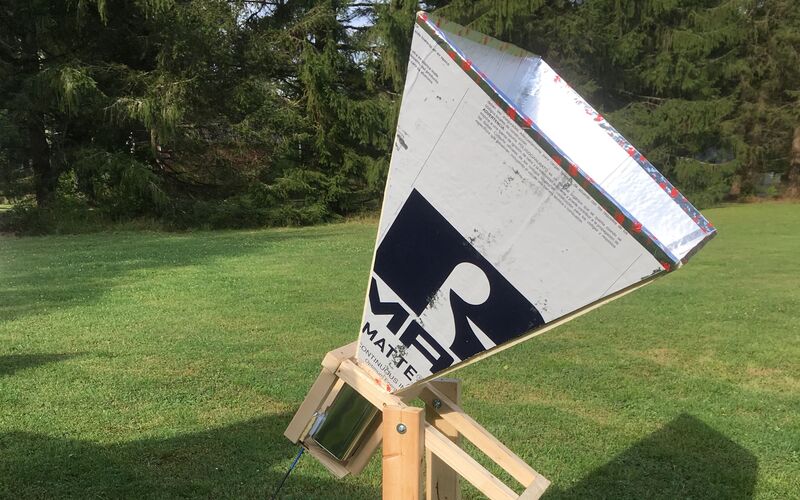 A finished horn telescope on its wooden stand in a field.
